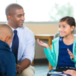 Elementary Age Kids Talking To Counselor During Group Therapy Session
